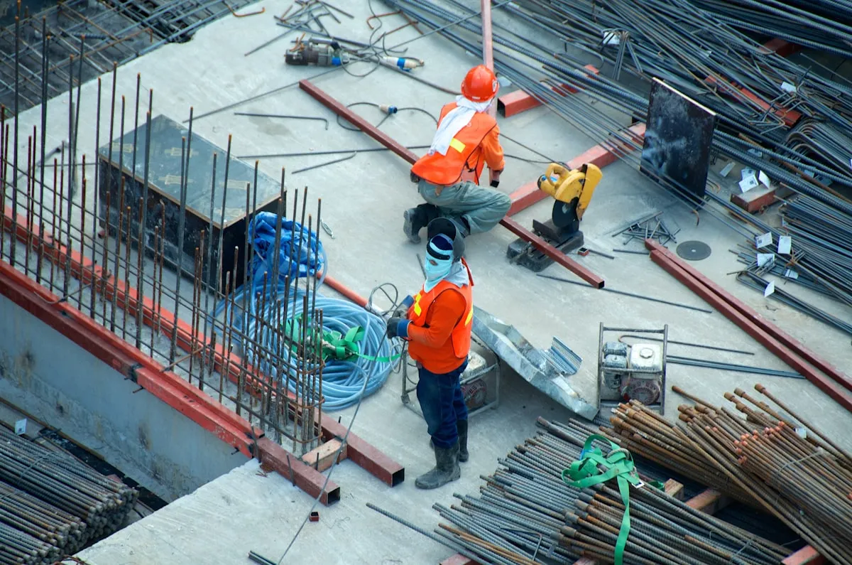 Small building firm owner reviewing construction management software on mobile phone at UK building site
