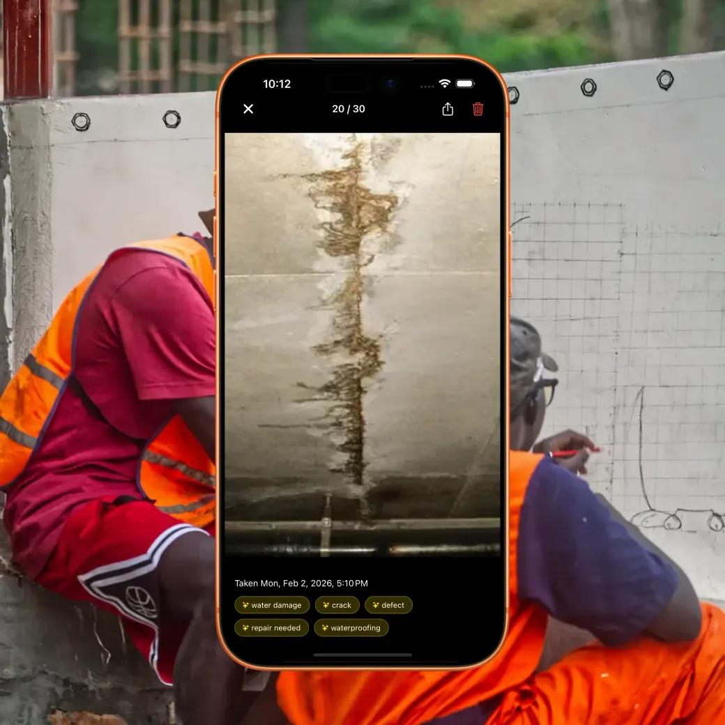 BuildersAI AI-tagged photo log on a phone over two foremen reviewing plans on site